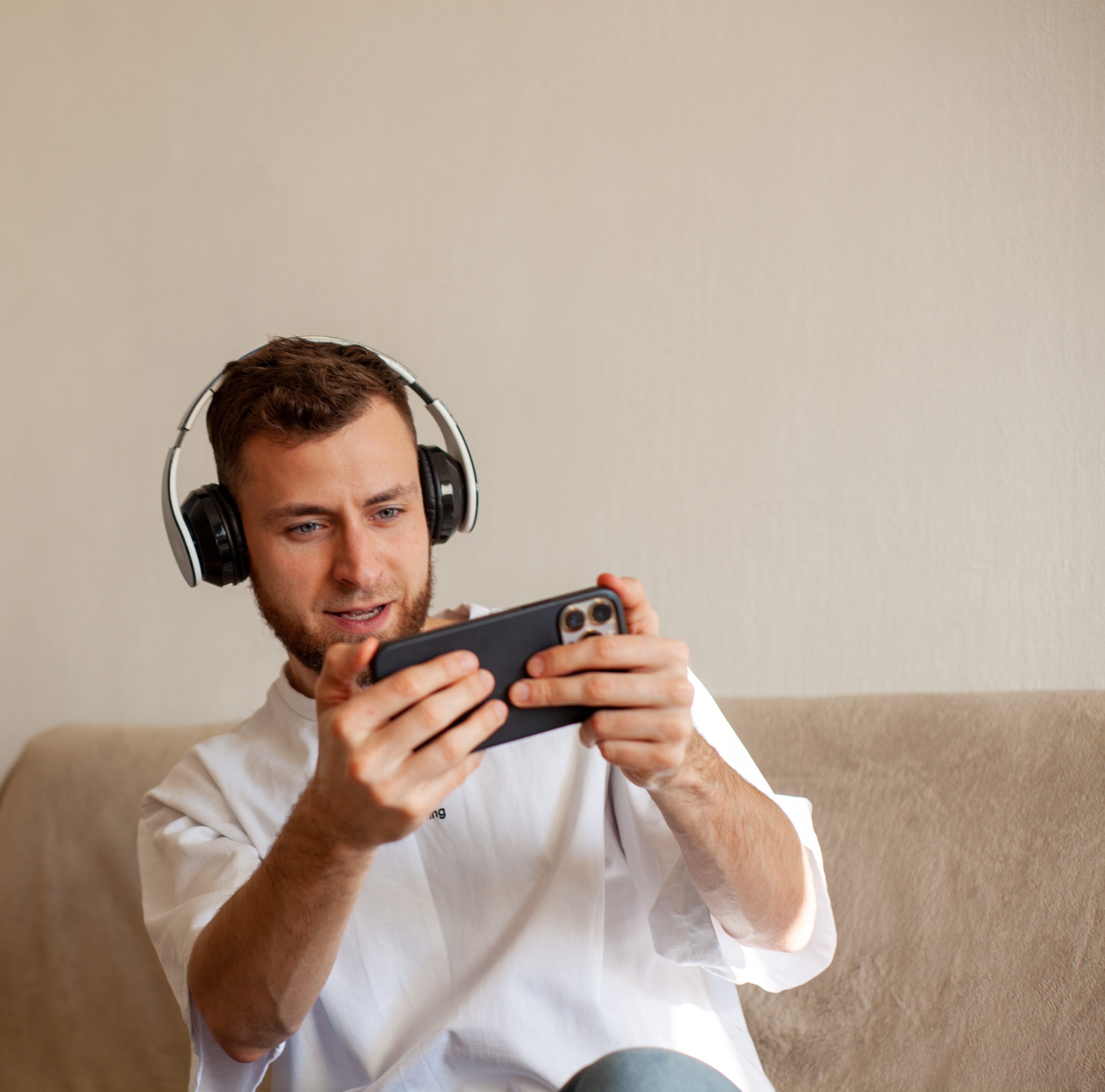 you man playing video games on mobile device with headset on