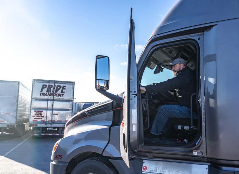 Pride employee with an open driver side door of a truck