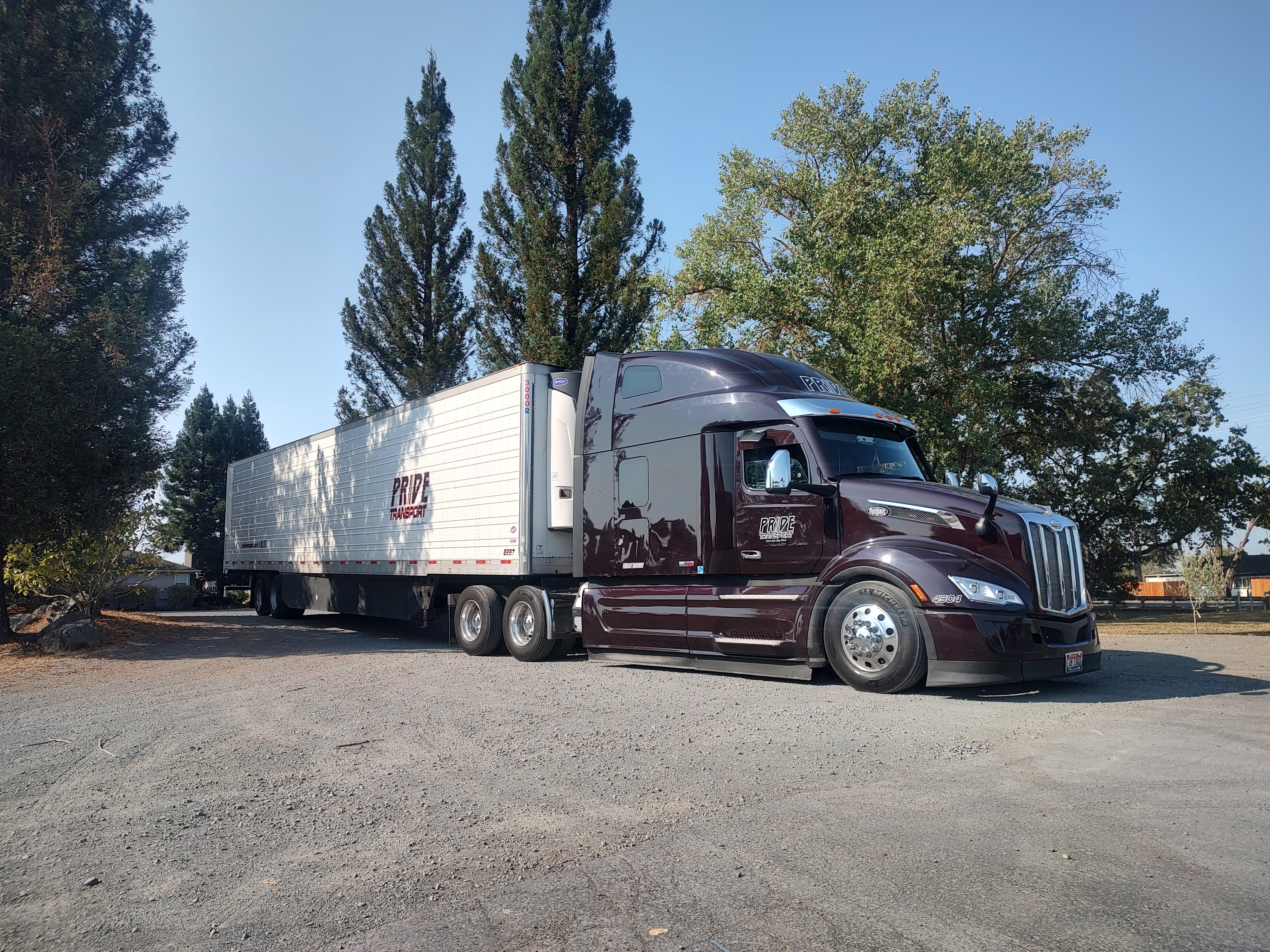 maroon pride transport truck trees in background