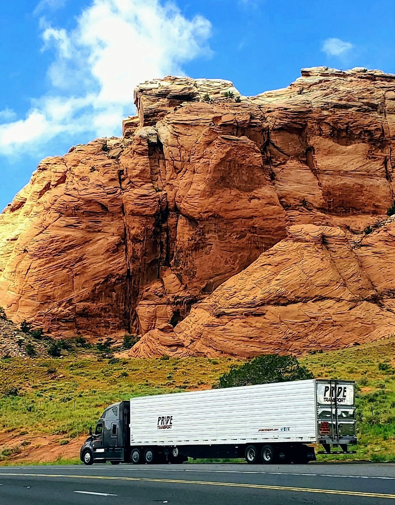 pride transport truck red rock landscape background