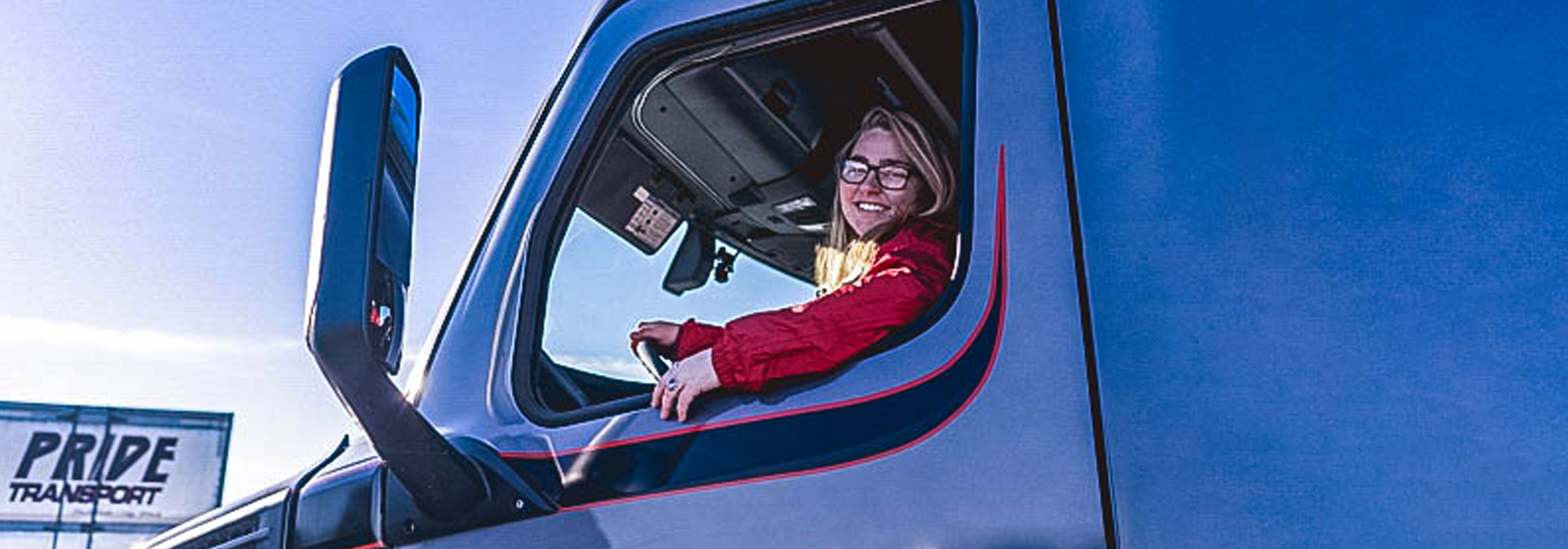 woman truck driver looking out semitruck window