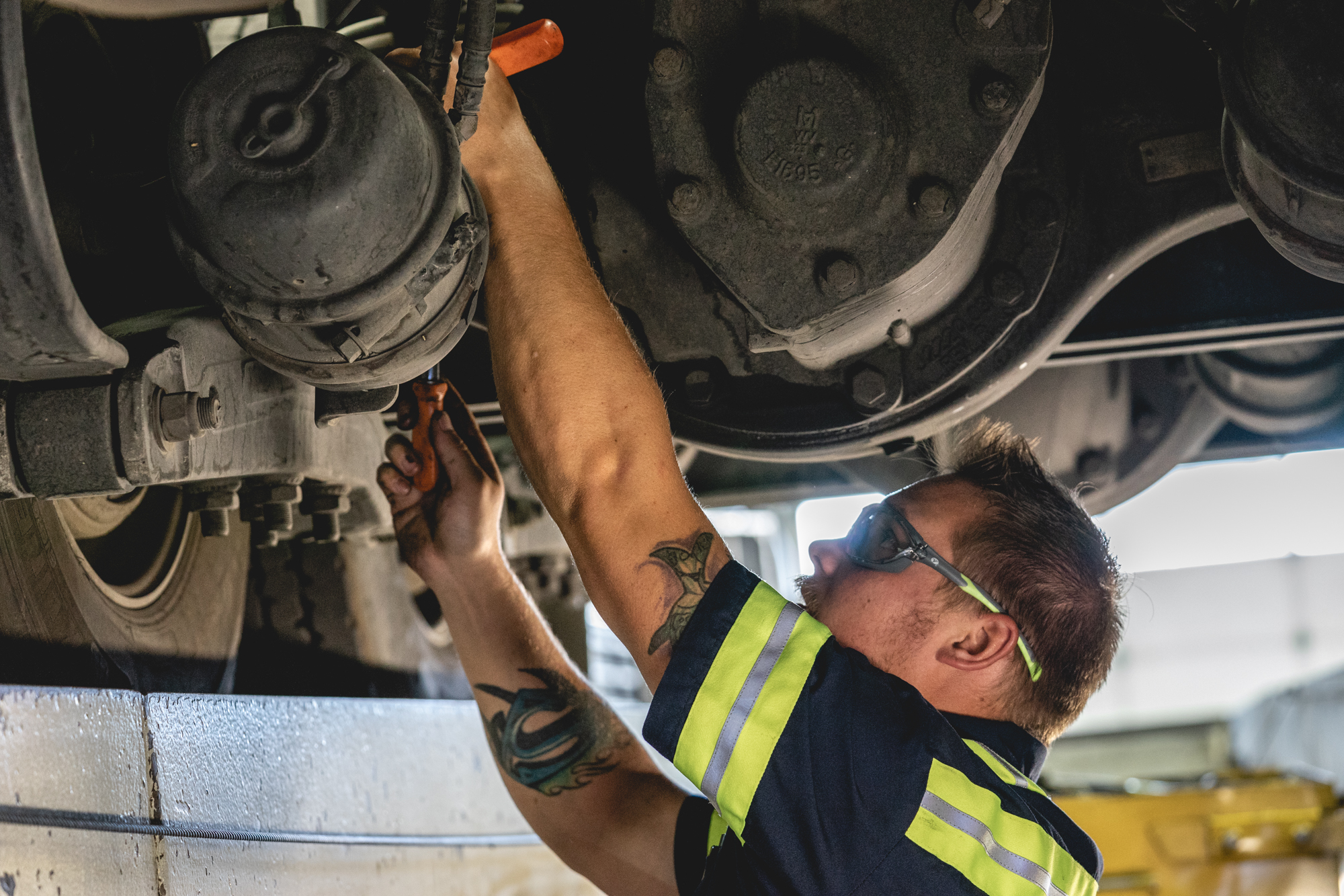 Pride Transport maintenance crew employee underneath a truck working