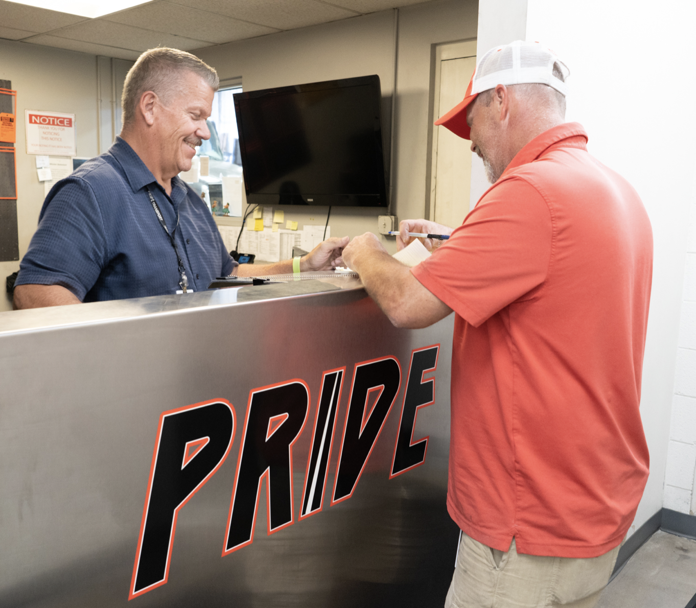 Pride Transport employee behind a counter helping another gentleman
