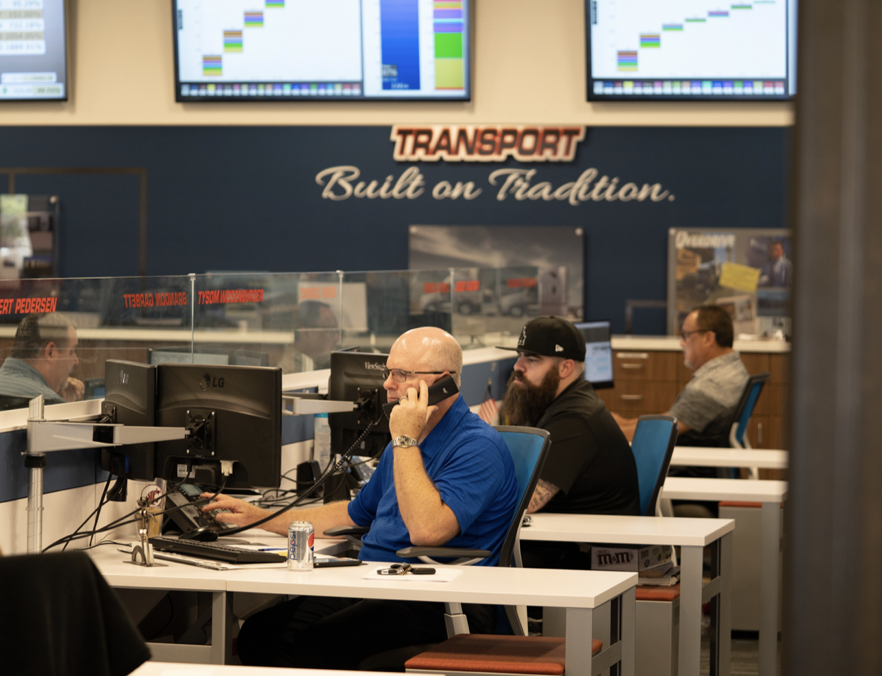 Pride Transport office employee on the phone and sitting at a desk in front of a computer