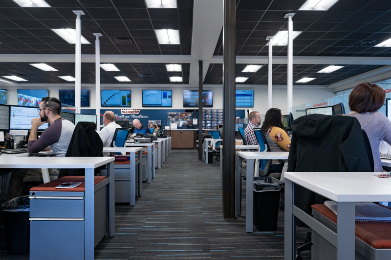 cubicle offices on both the left and right hand side of the image and hallway down the middle