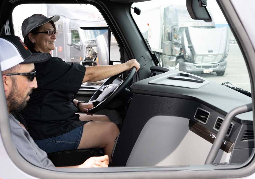 man and woman team truck drivers in the cab of a semi truck