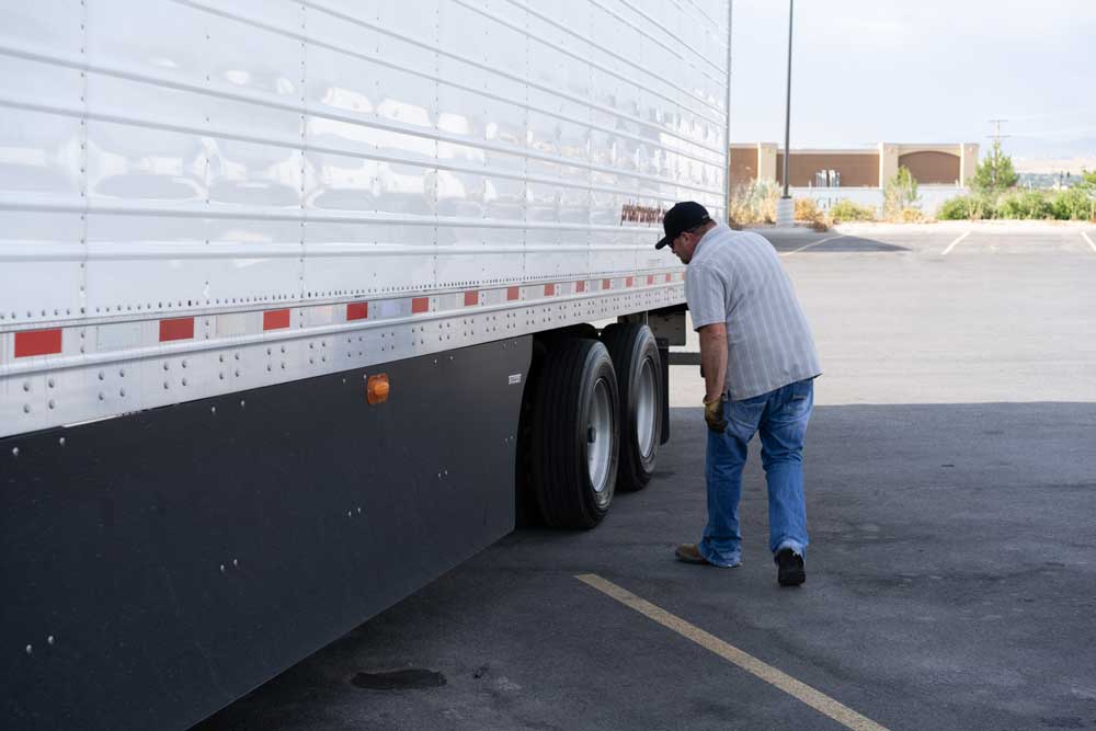 man checking his semi truck trailer