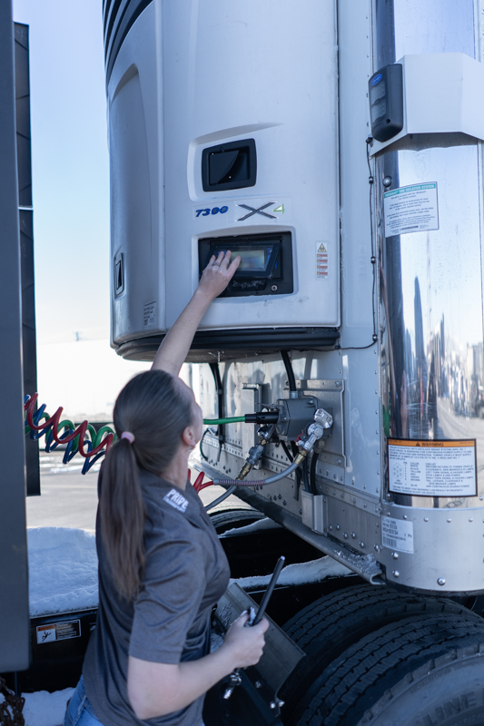 female pride transport driver inspecting truck