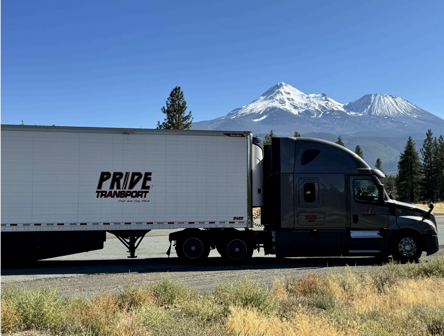 pride transport truck parked in front of snow capped mountain