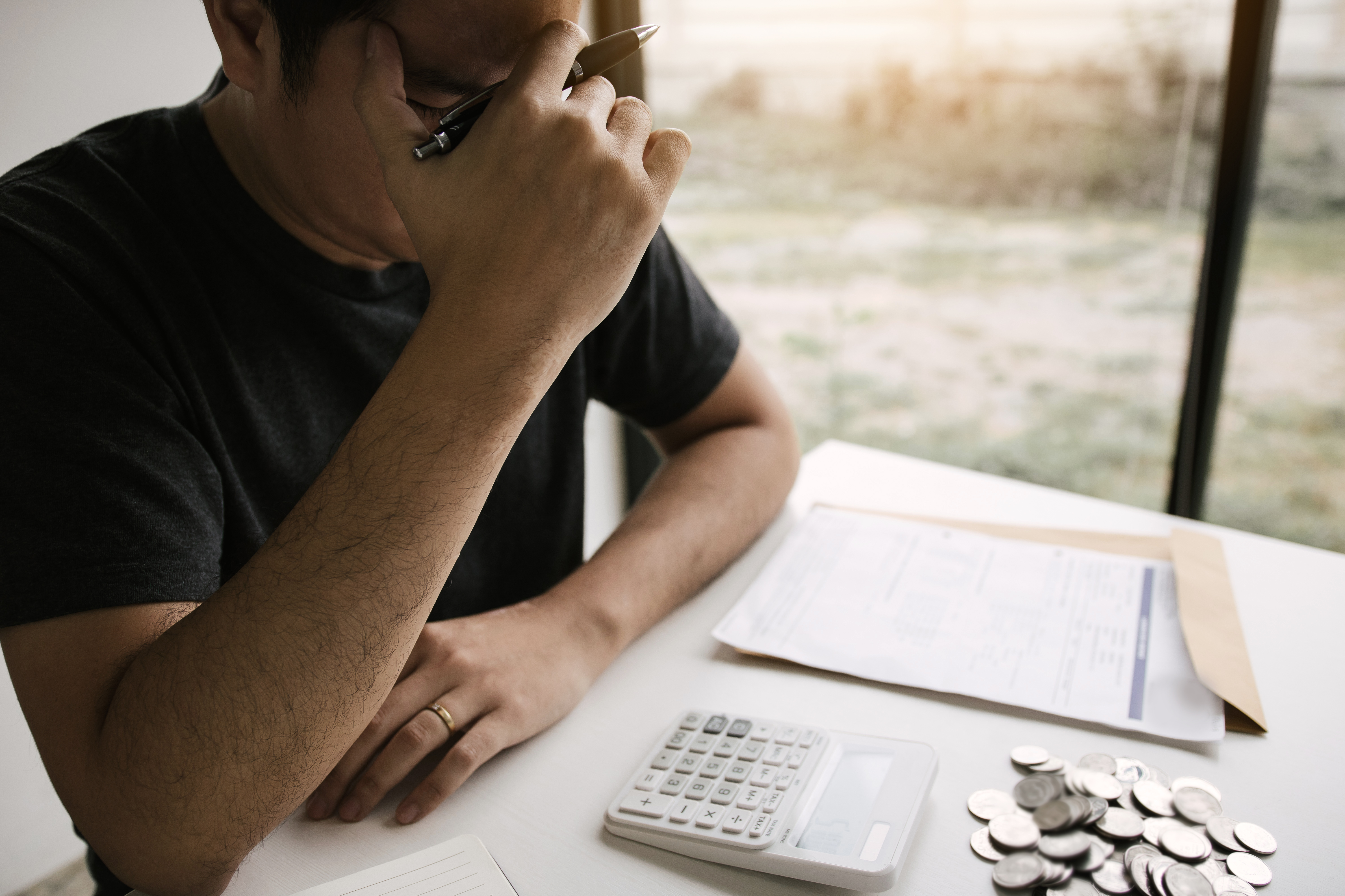 image of a man counting money and looking stressed