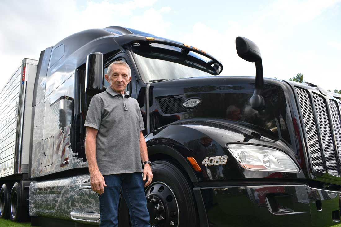 jeff england standing in front of a military themed custom painted peterbilt semi truck