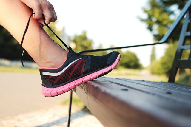 tying shoe on bench