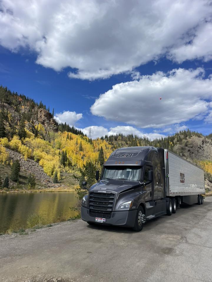 pride transport truck parked with fall mountainscape in background