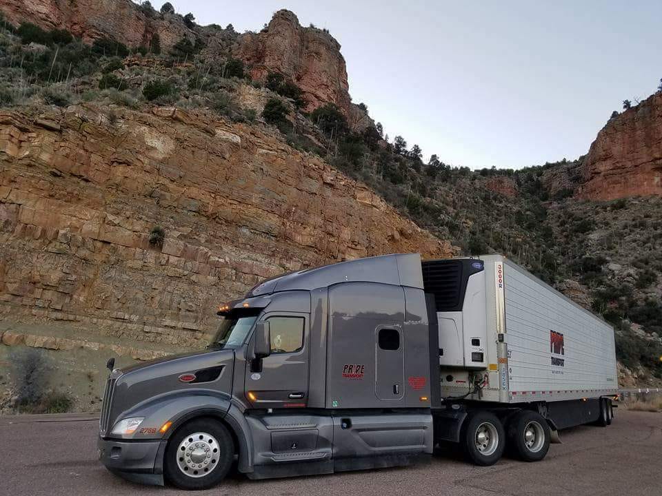 pride transport truck with red rock in background