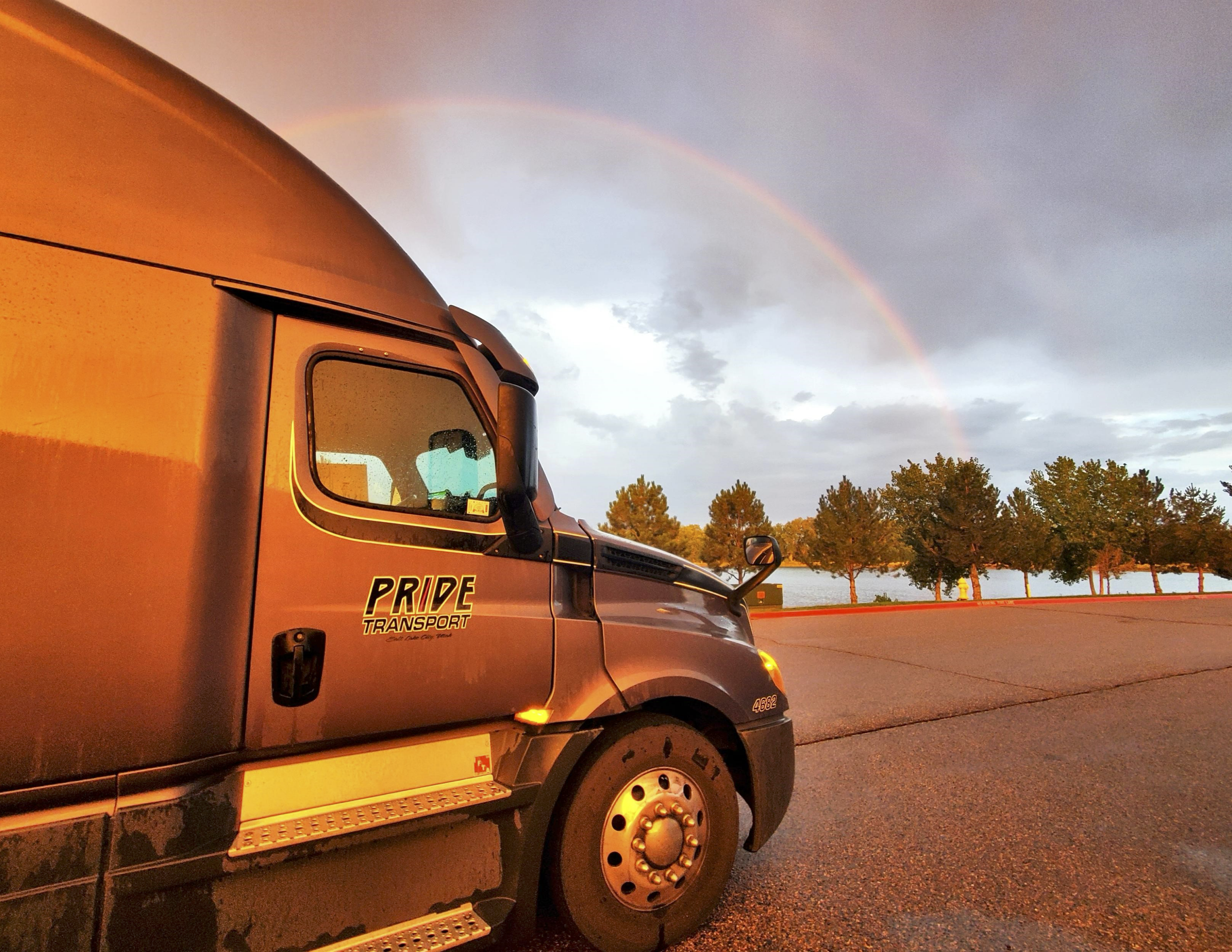 pride transport truck in front of rainbow