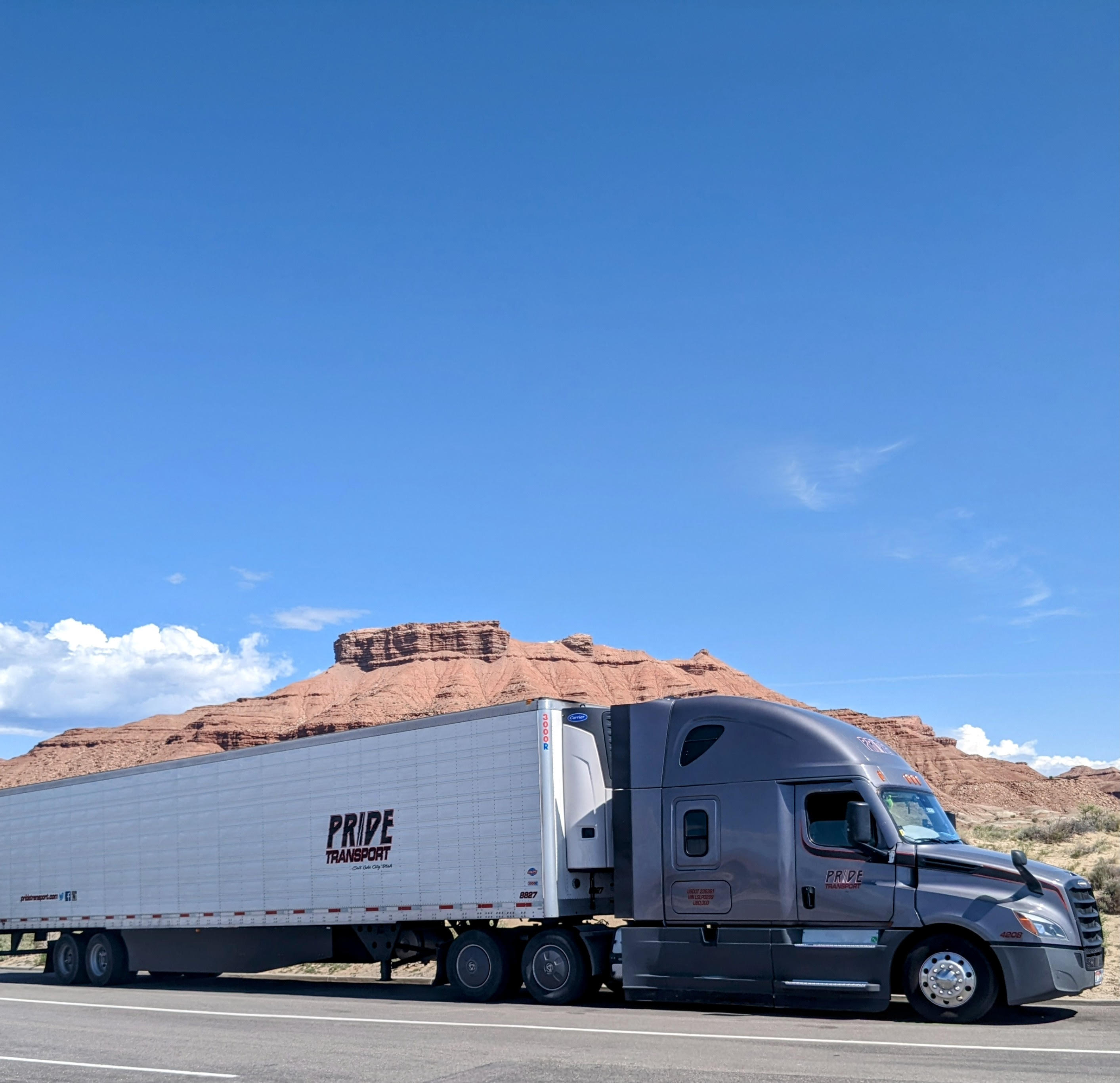 pride transport truck parked with red rock mountainscape in background