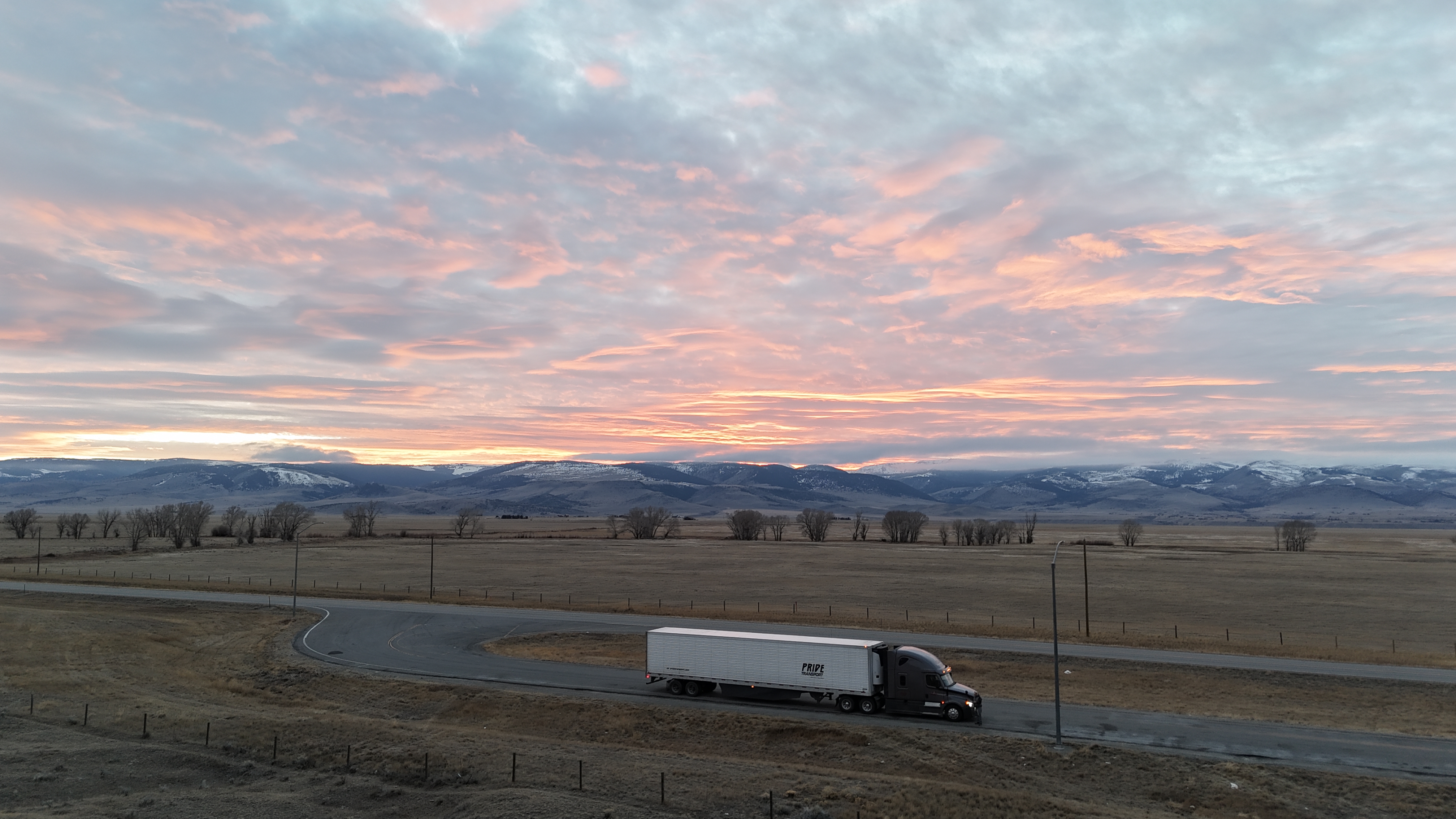 overhead drone photo of pride transport truck parked with sunset in background