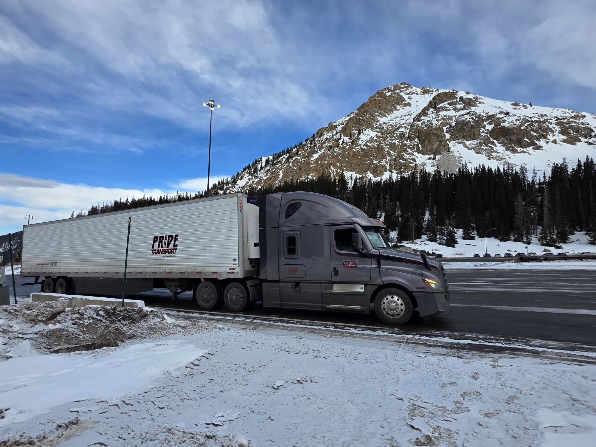 pride transport truck parked snow mountainscape in background