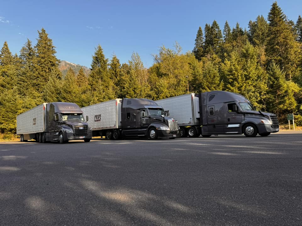 three pride transport trucks parked together