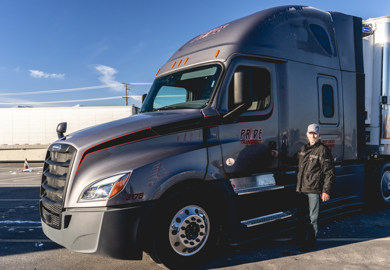 pride transport driver standing at driver door of semi truck