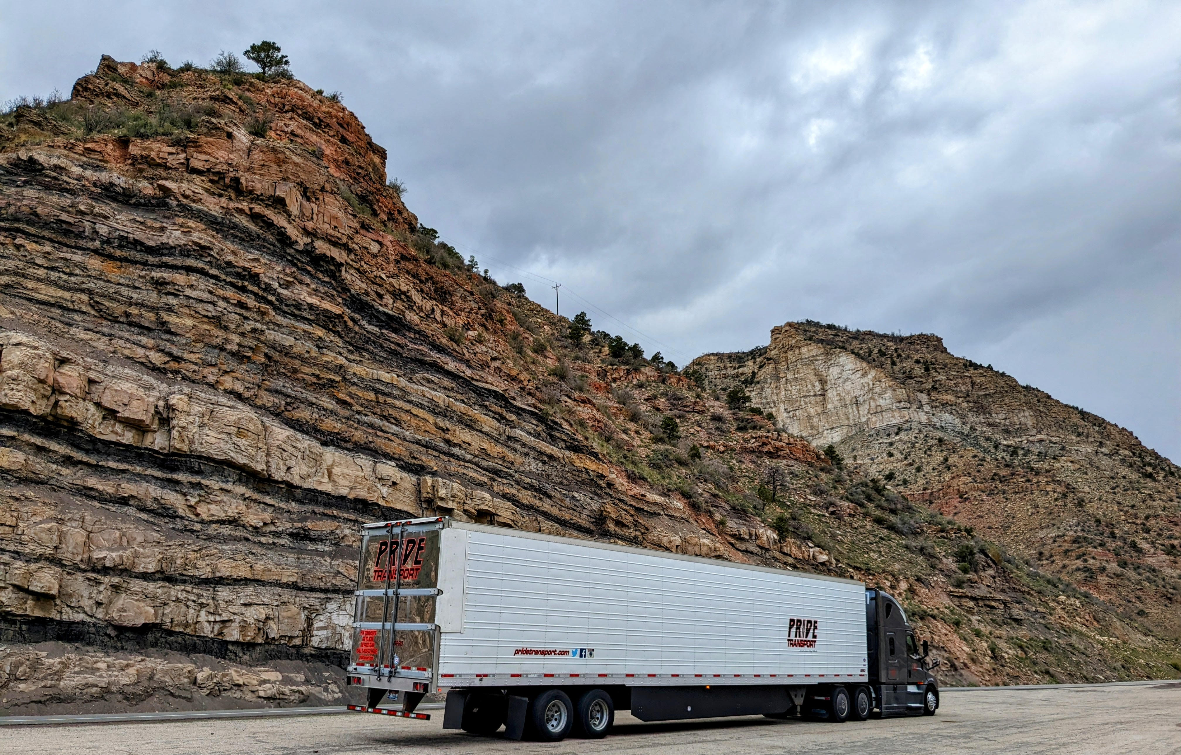 rearside of pride transport truck with red rock mountains in background