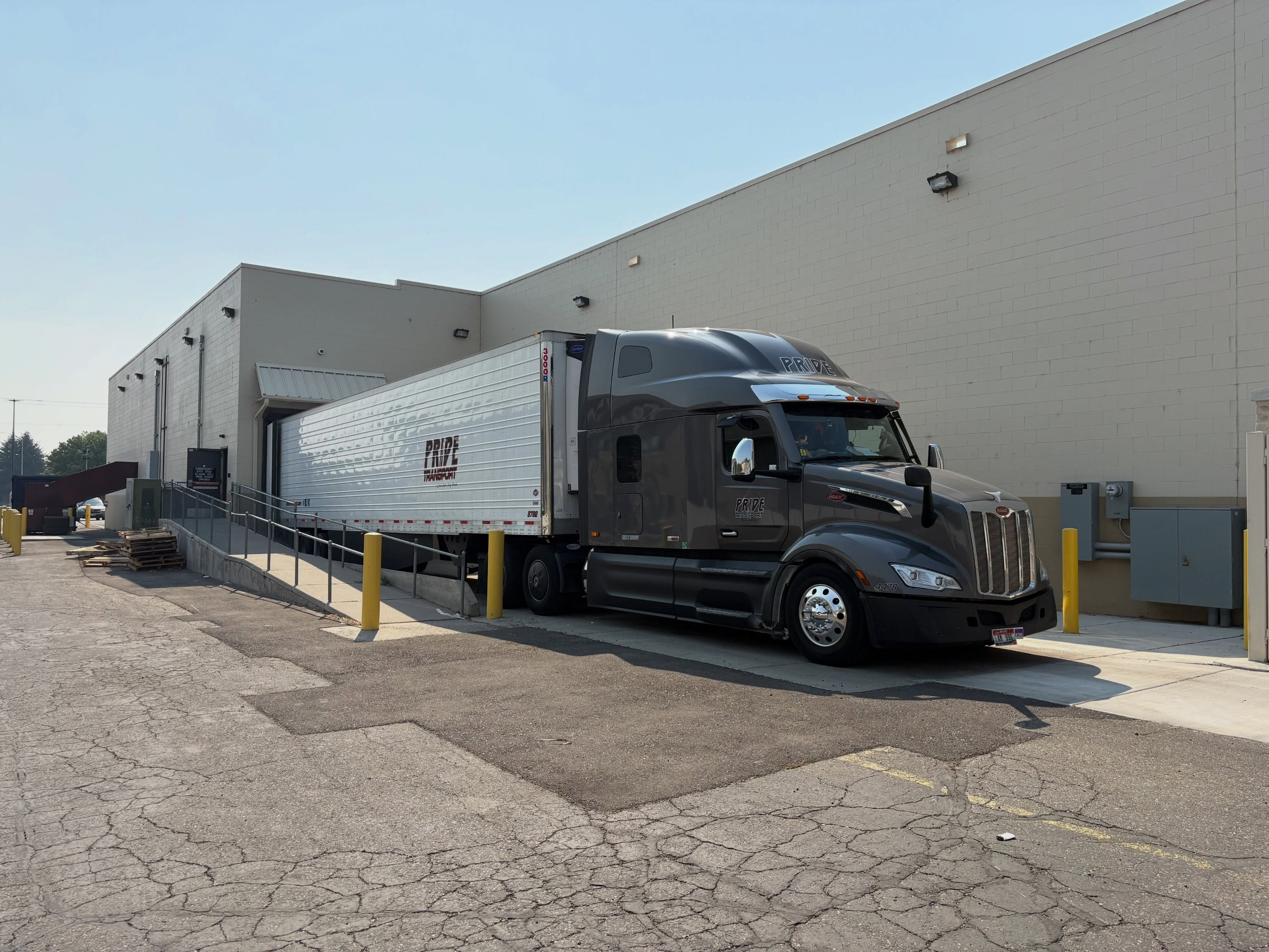 side angle of pride transport truck backed into loading dock