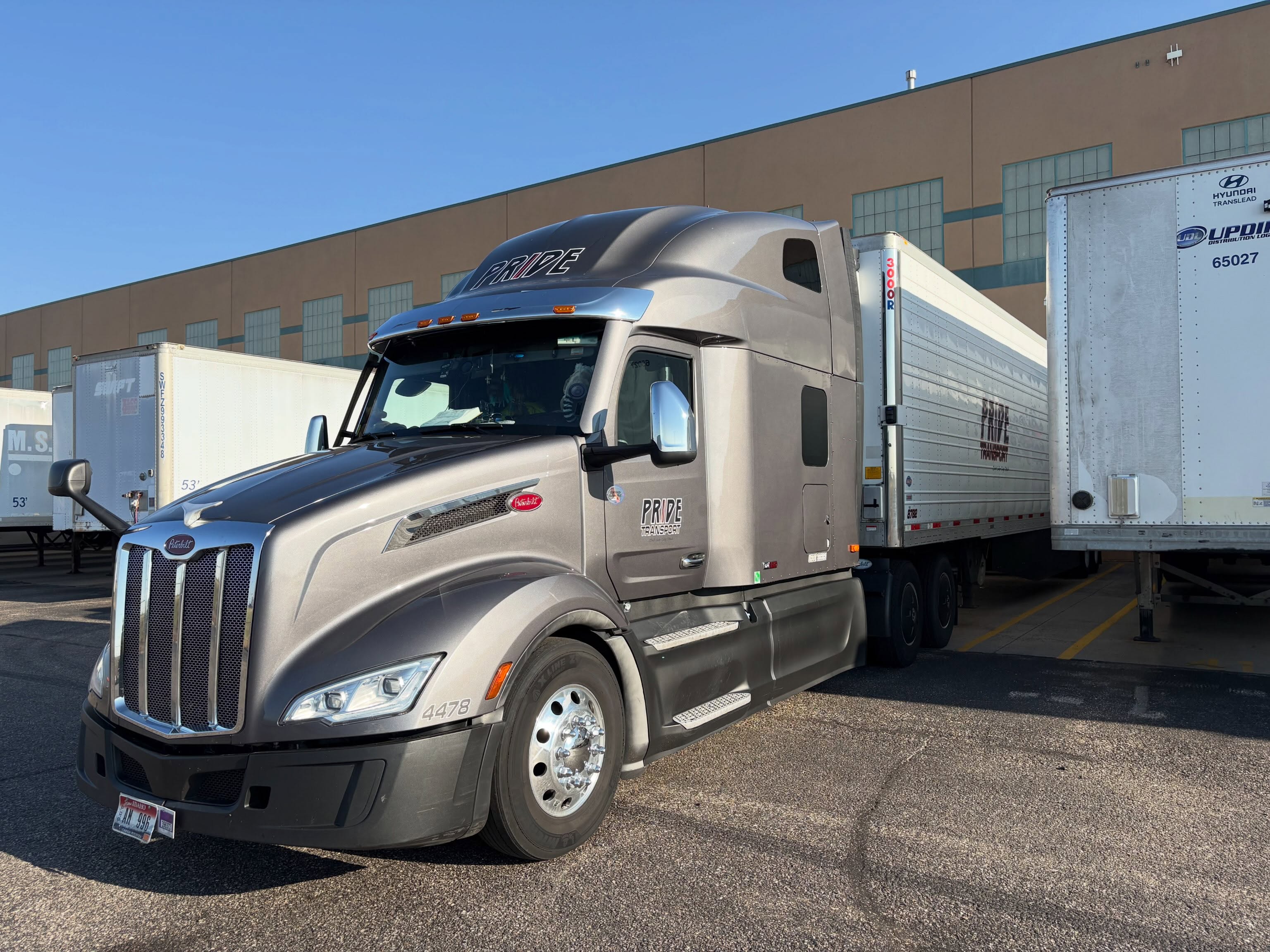 pride transport truck backed into loading dock with other trucks