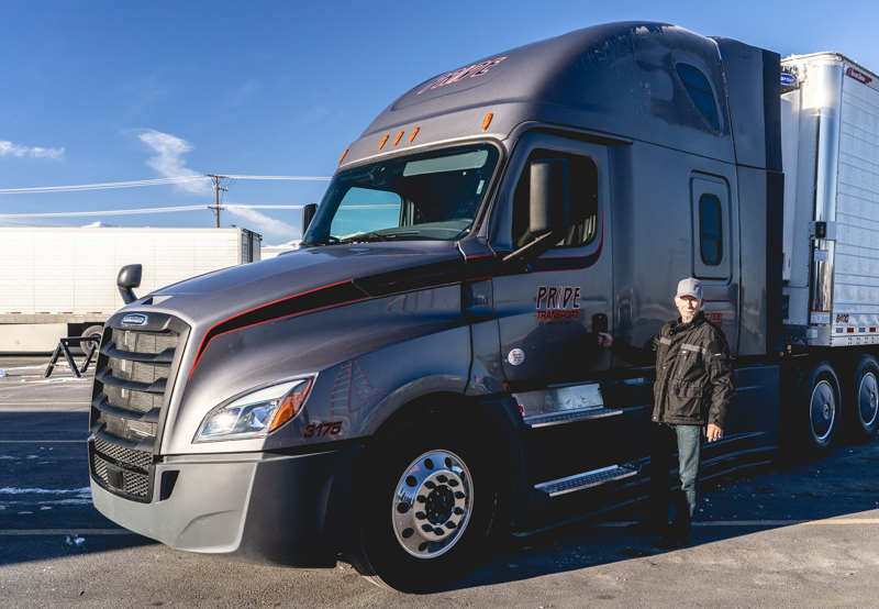 pride transport truck with an employee in front