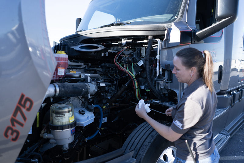 pride transport driver checking oil of pride transport truck