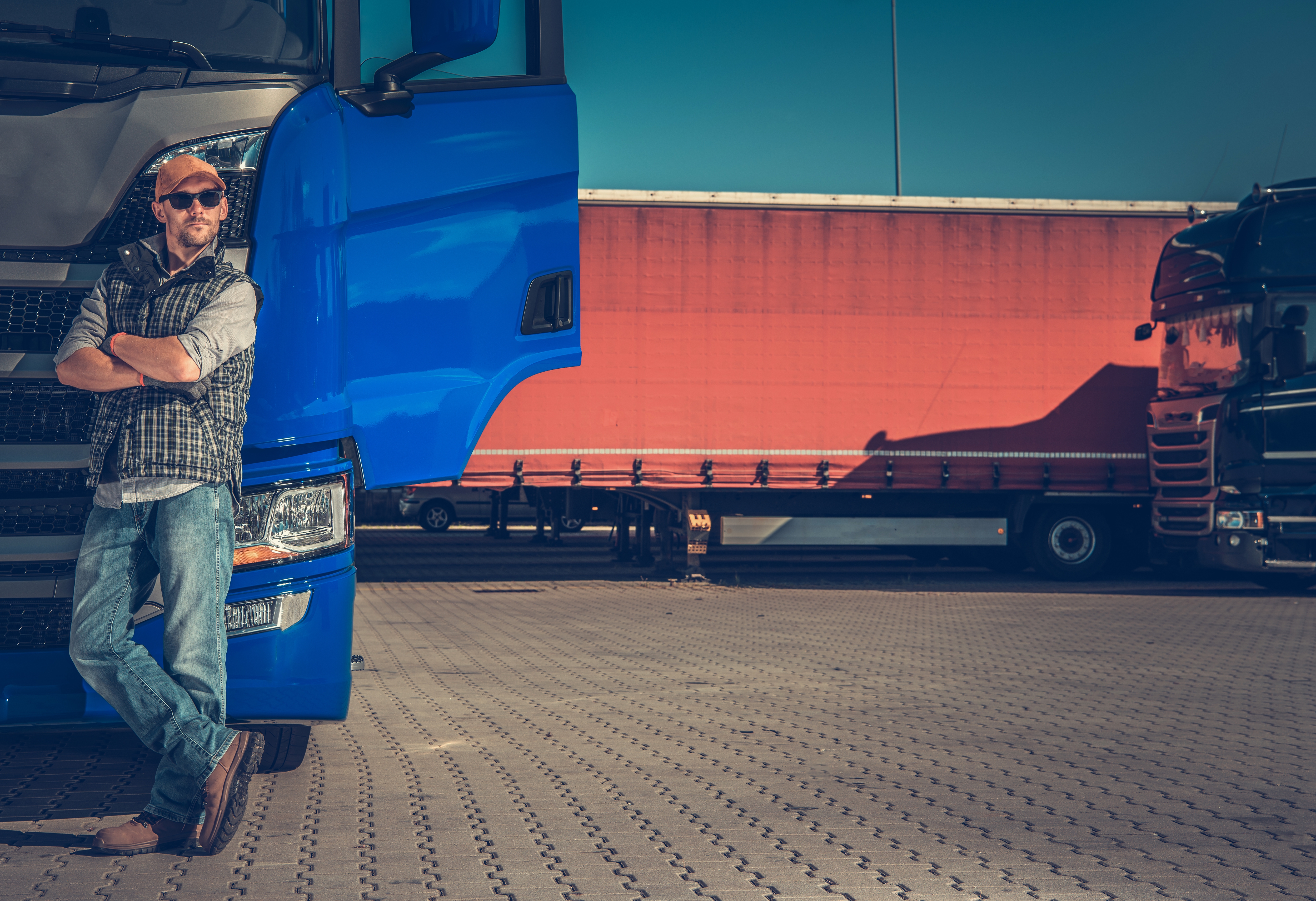 man leaning against a truck at a truck stop