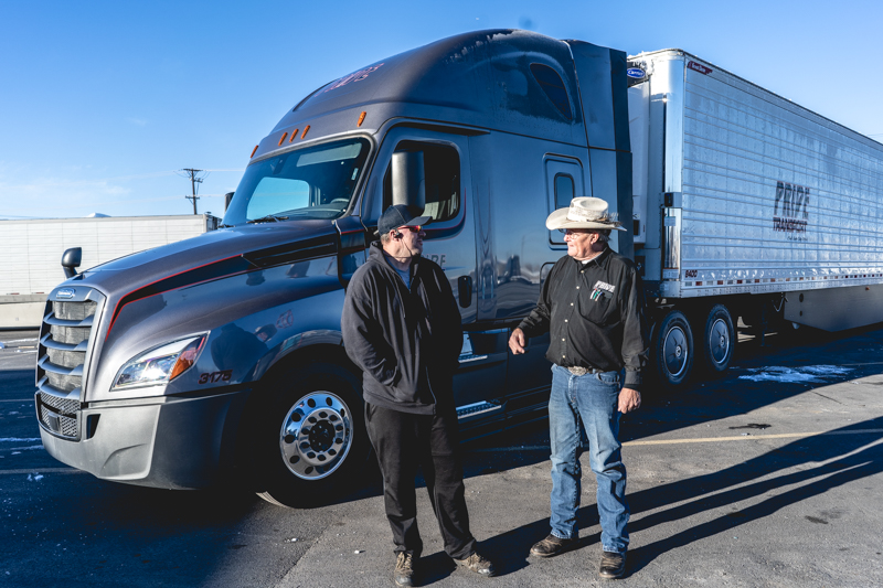 pride transport employees laughing in front of truck