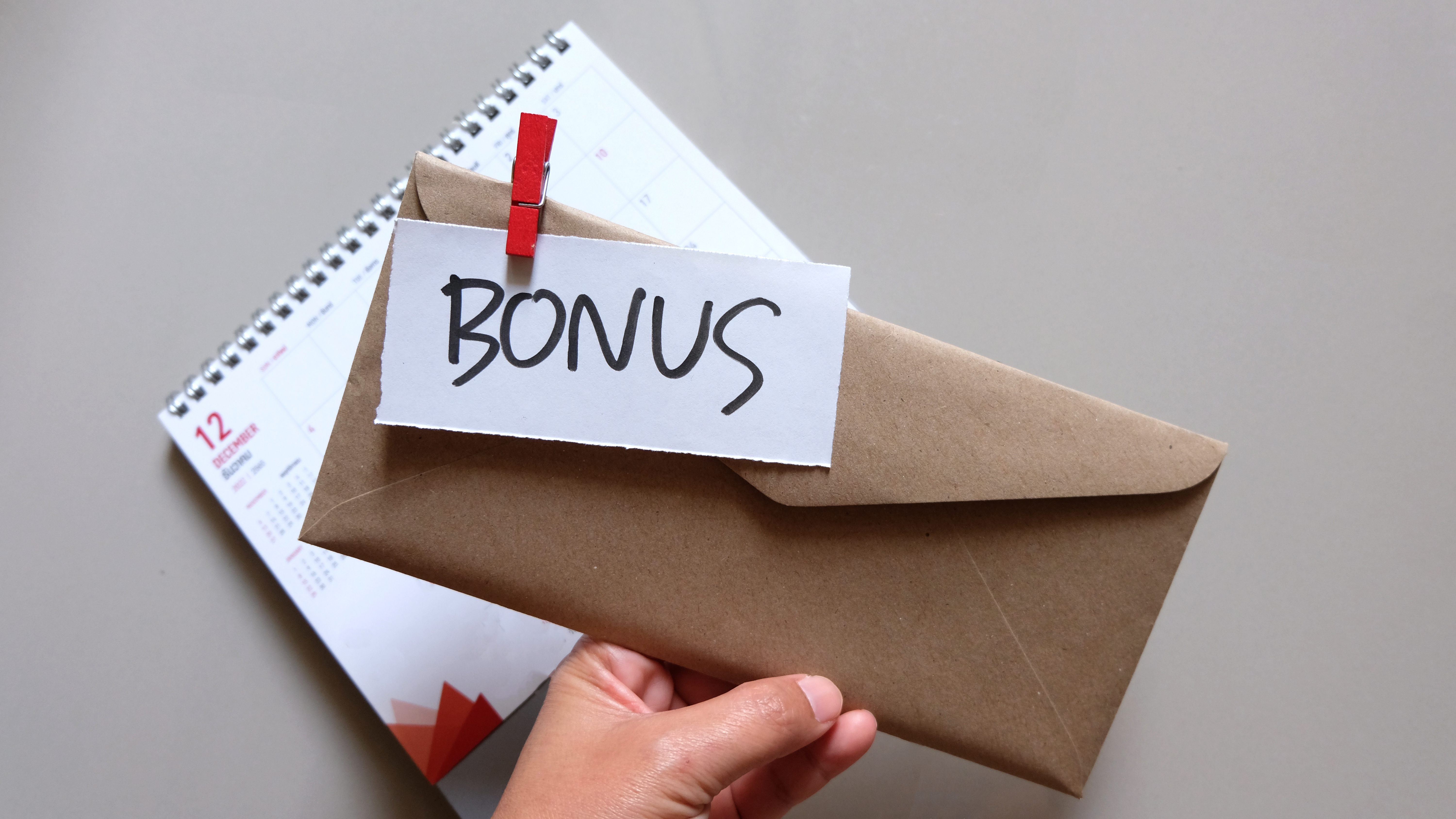 hand holding an envelope with the word bonus written on it