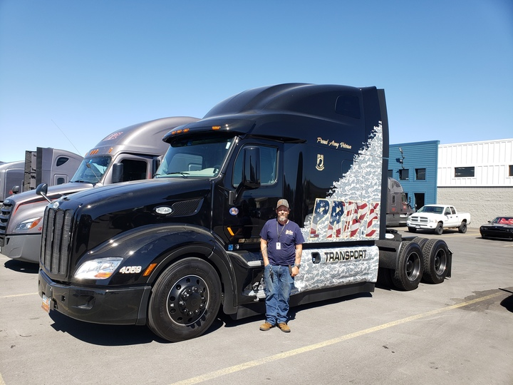 Pride Transport driver standing in front of POW MIA themed semi truck