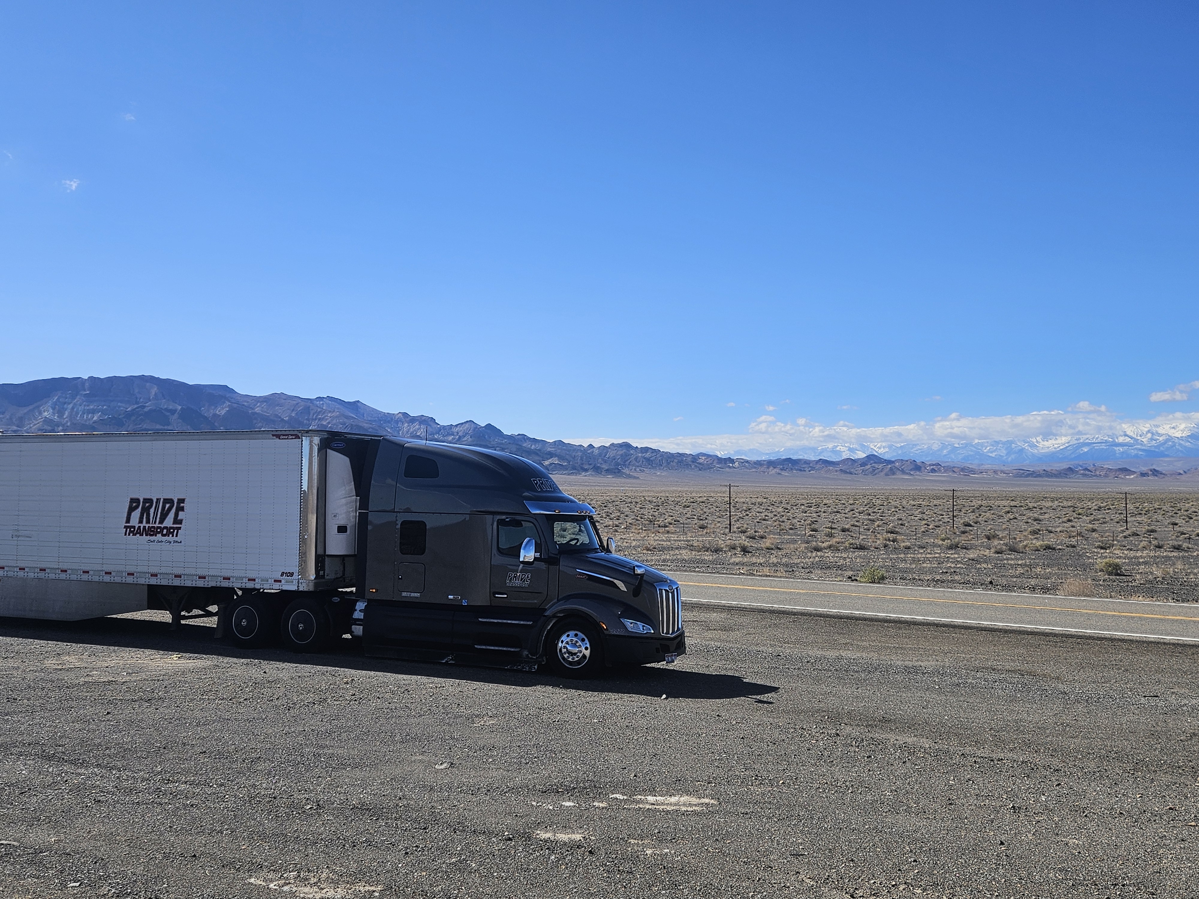 pride transport truck with mountains in background