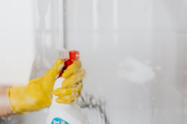 gloved hand spraying cleaner