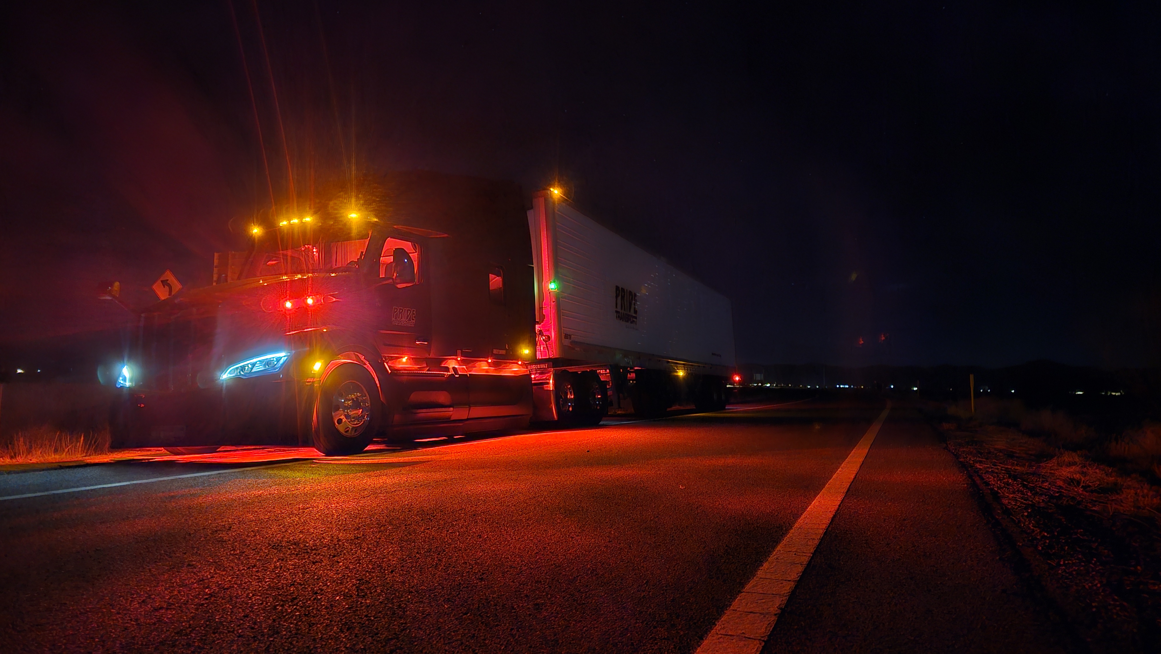 Pride transport truck at night with red lights shining