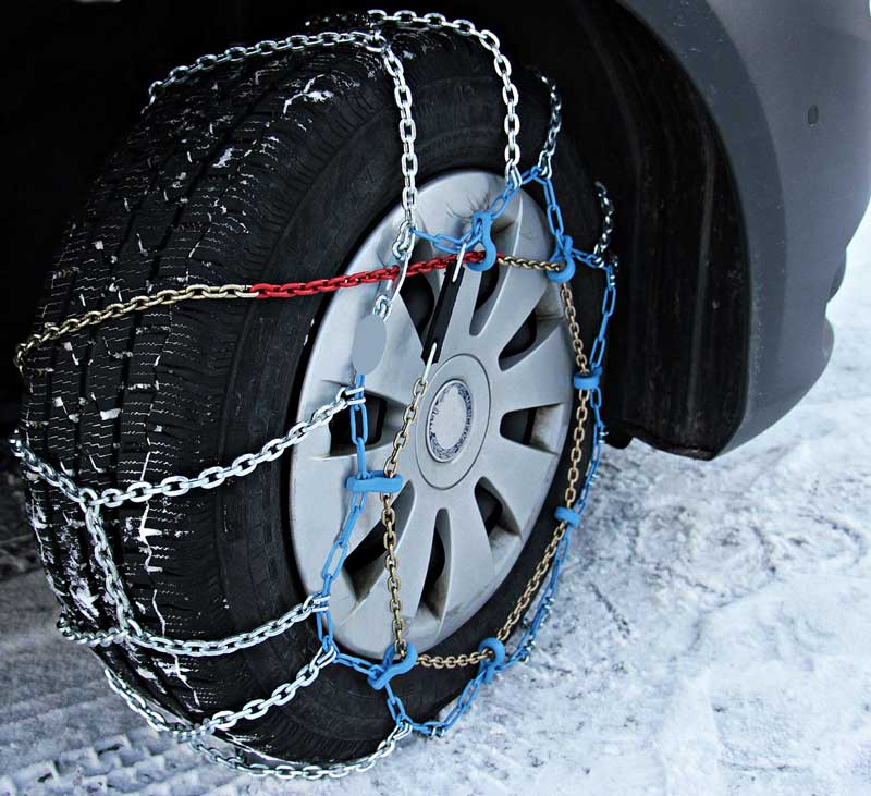 a passenger vehicle with snow chains on its tires