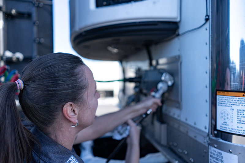 female Pride Transport employee working on truck