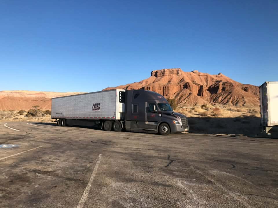 pride transport truck in front of red rock mountainscape