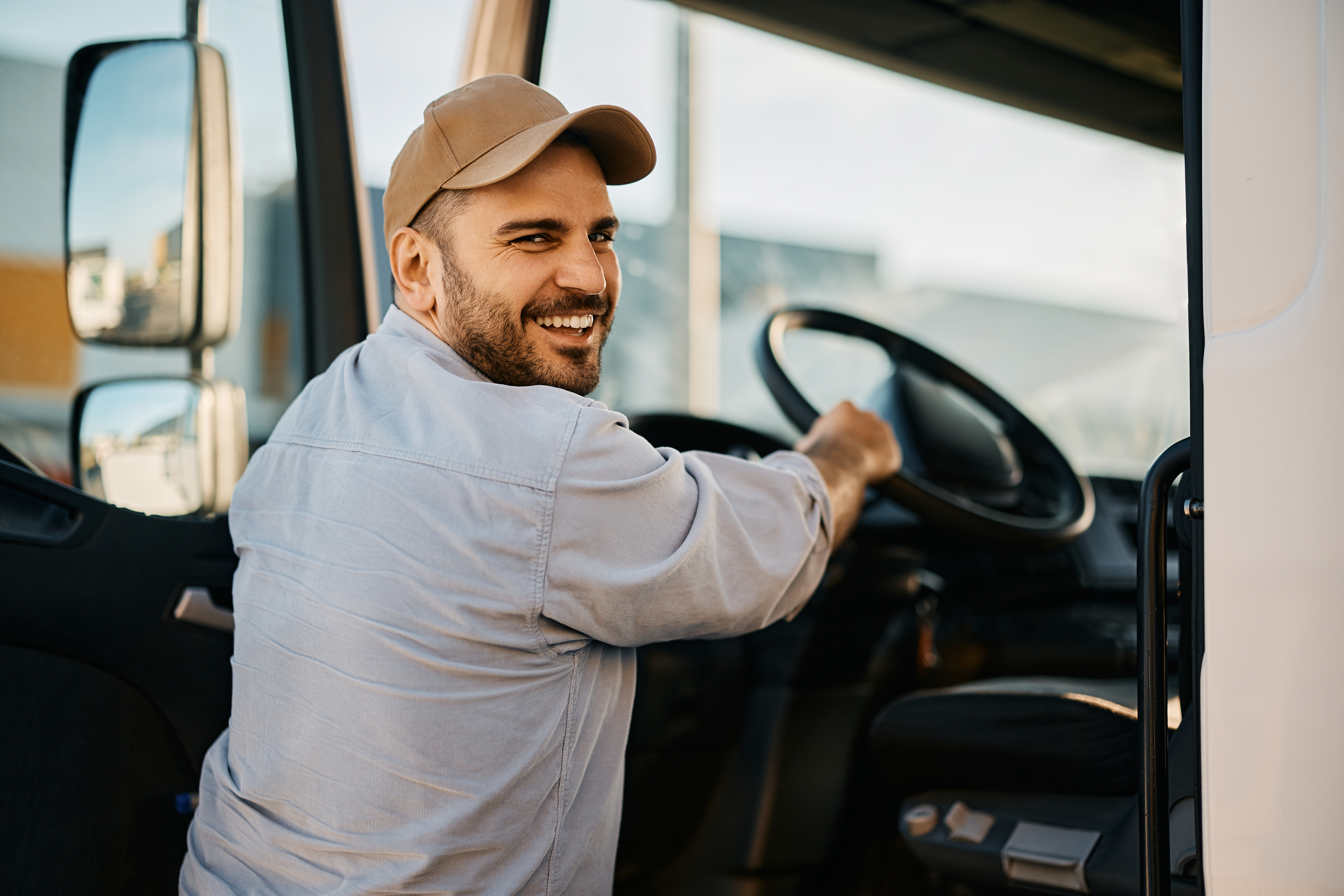 truck driver smiling at camera while getting in truck