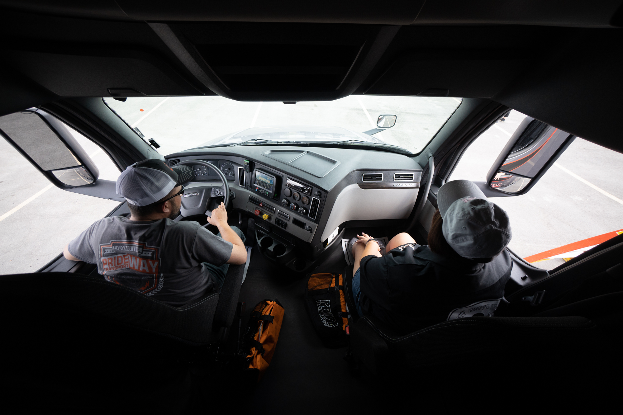two pride transport truck drivers inside cab