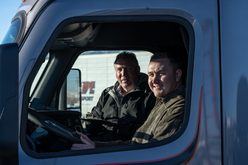 two truck drivers in pride transport truck