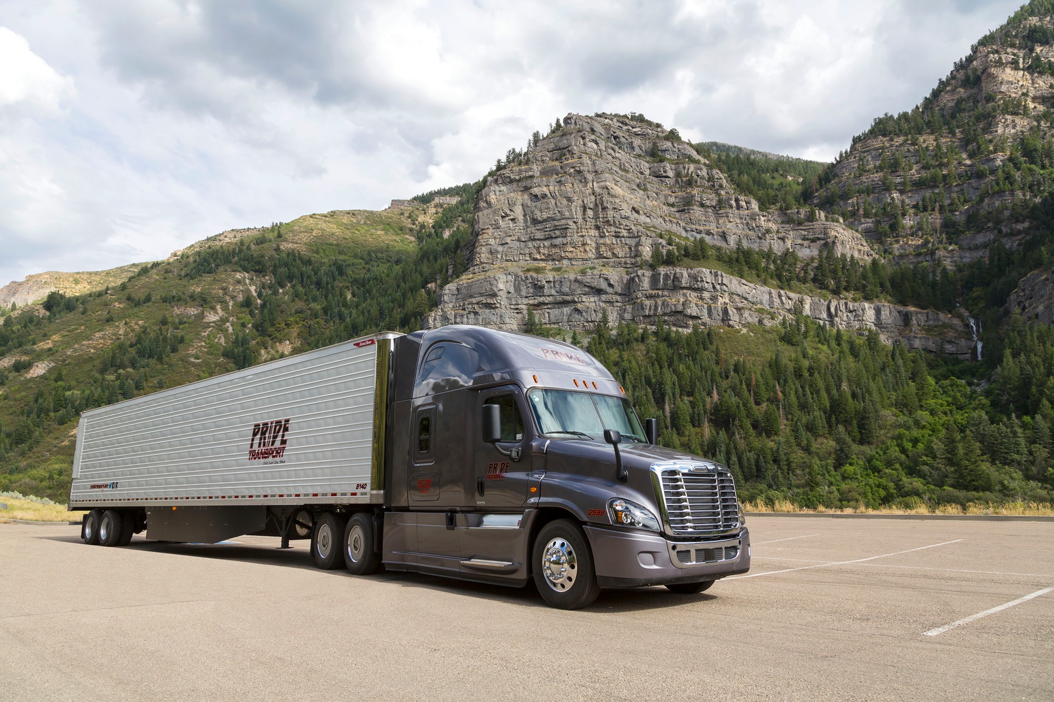 pride transport truck parked in front of mountain