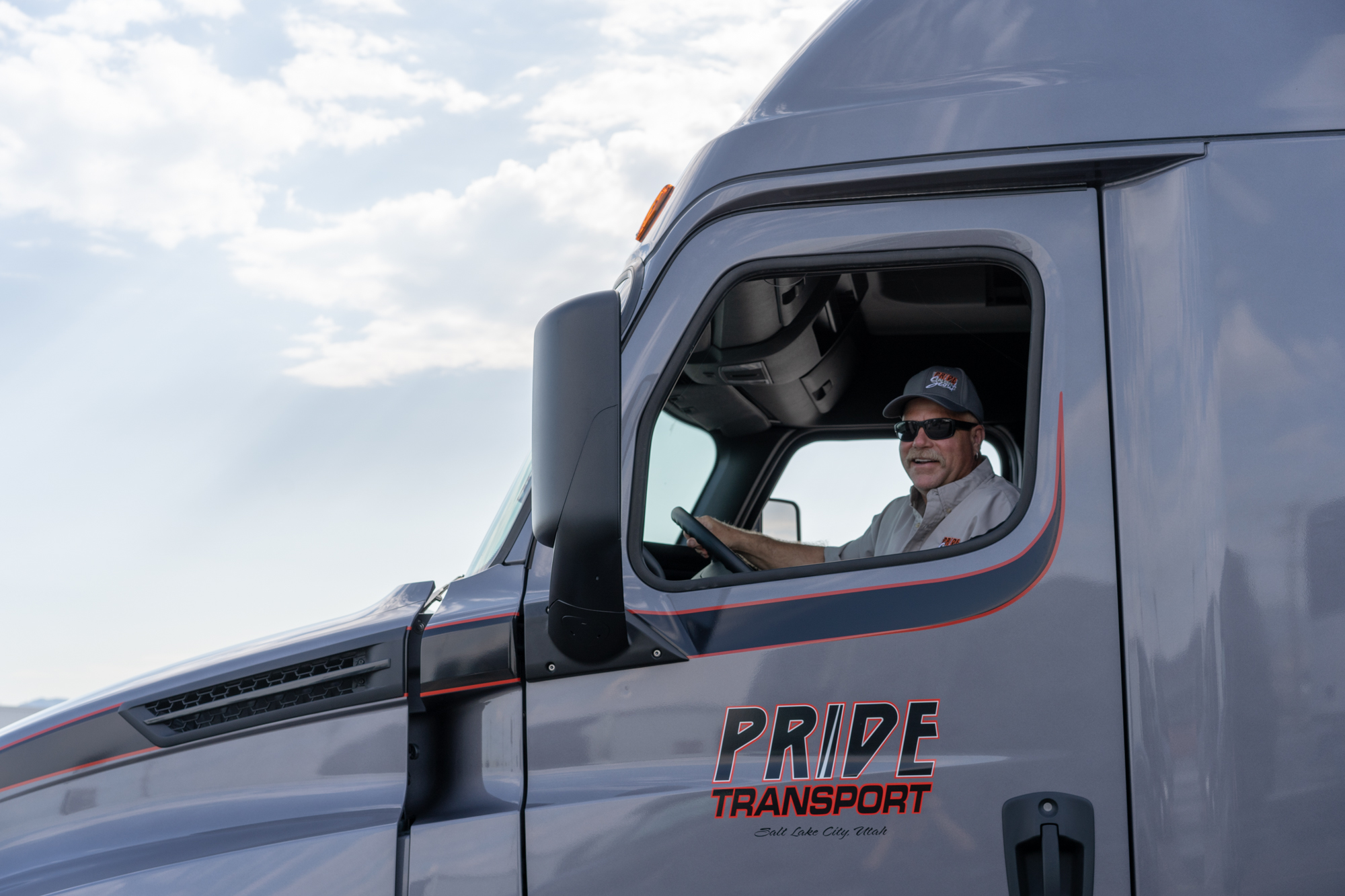 pride transport driver looking out the driver's side window smiling
