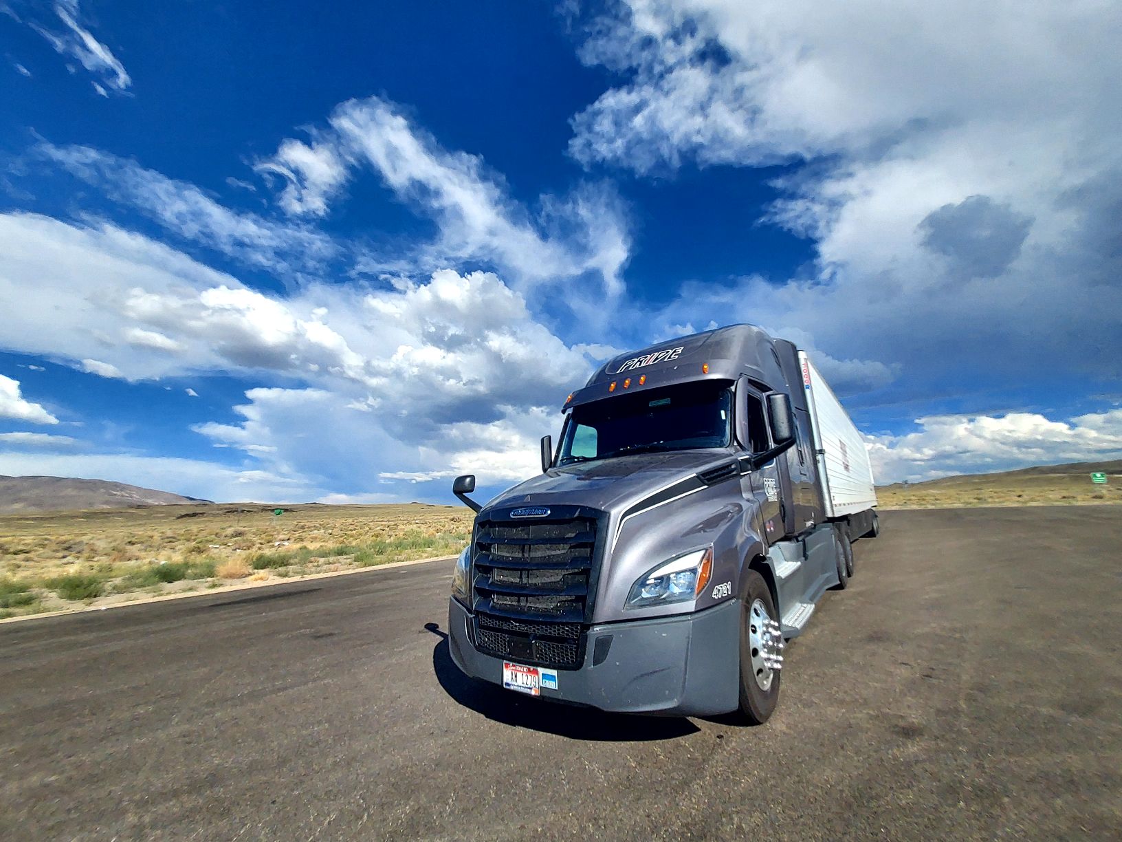 pride transport truck in empty lot with blue sky background