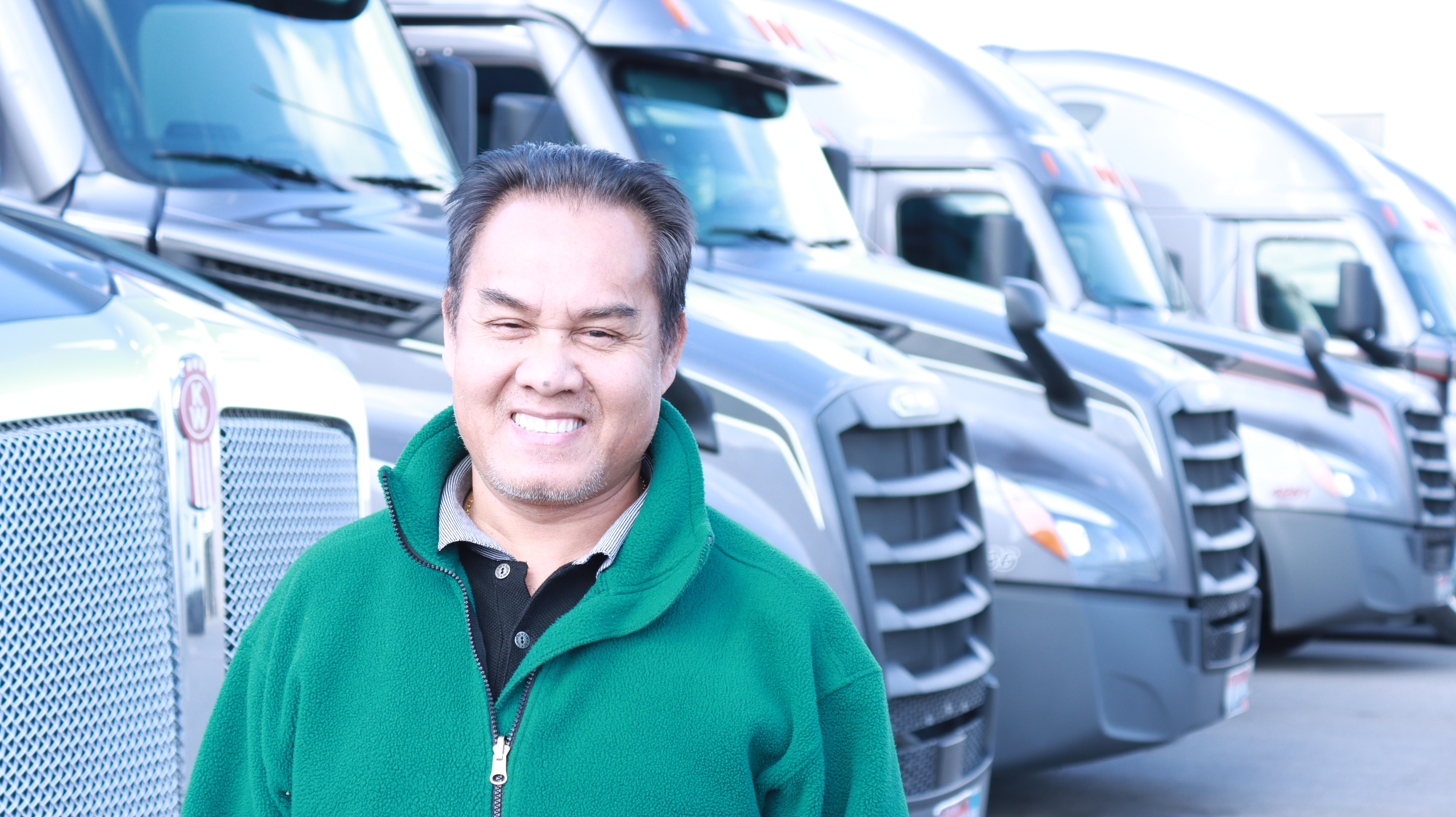pride transport employee smiling in front of truck