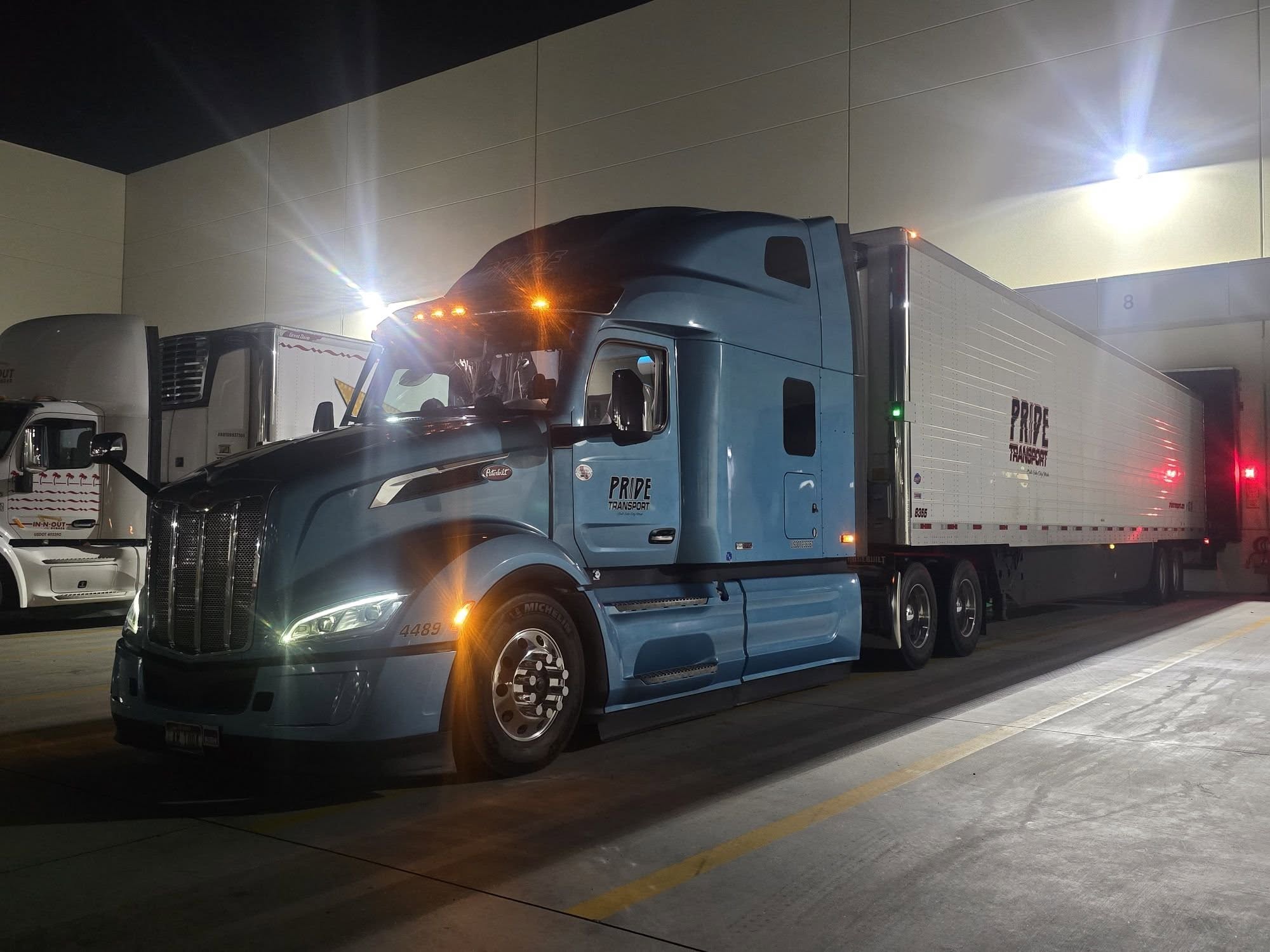 blue pride transport truck backed in at night