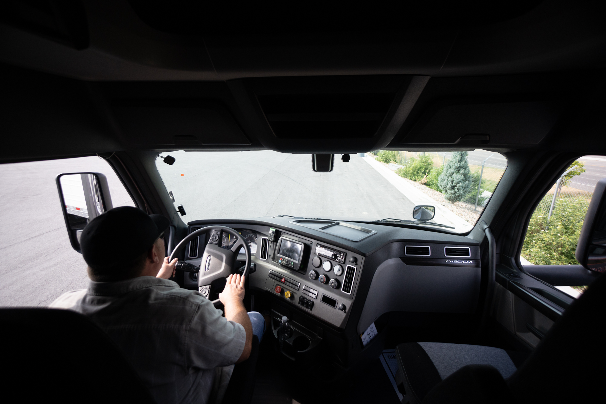 interior behind view of pride transport truck driver driving