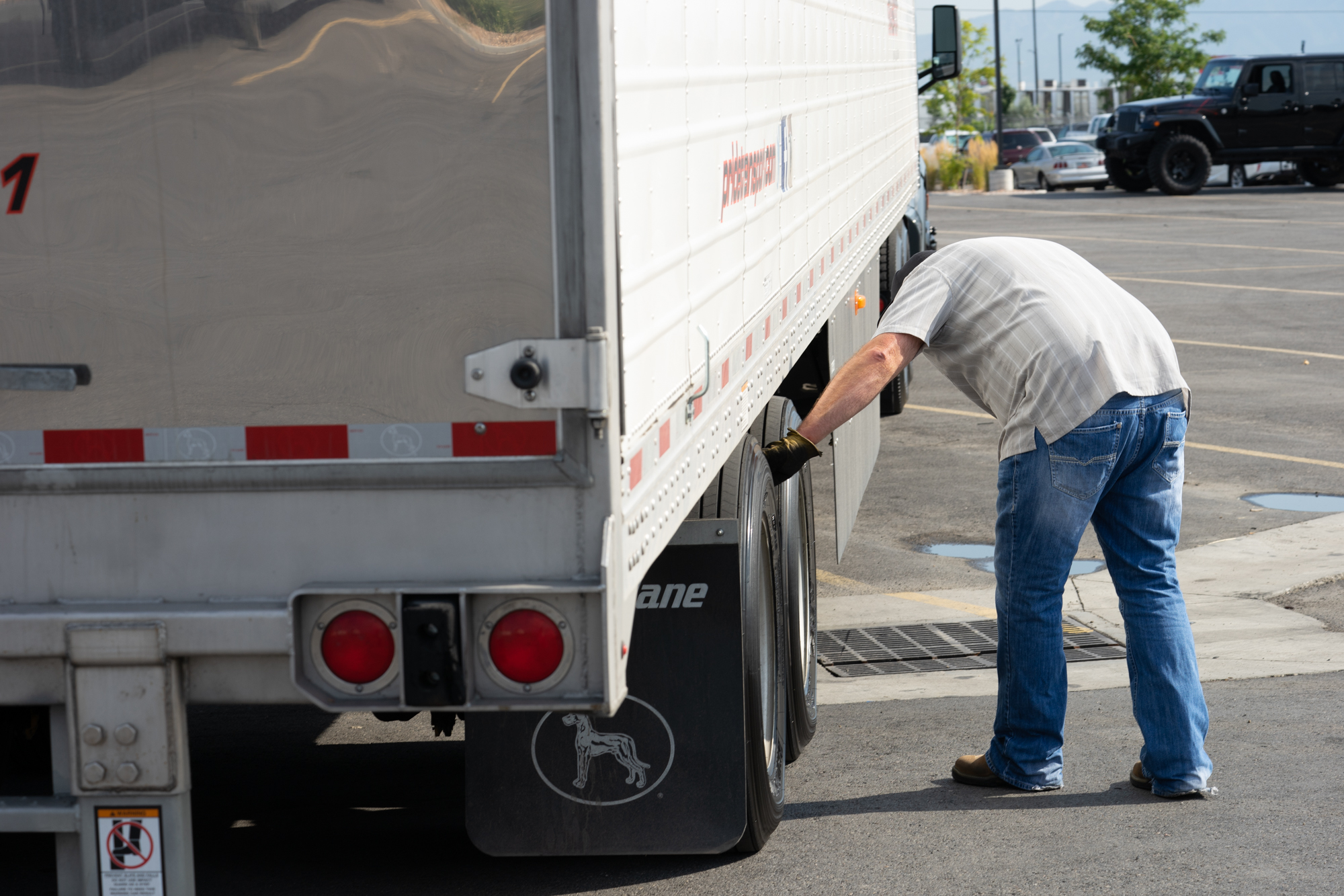 pride transport employee checking tire on truck