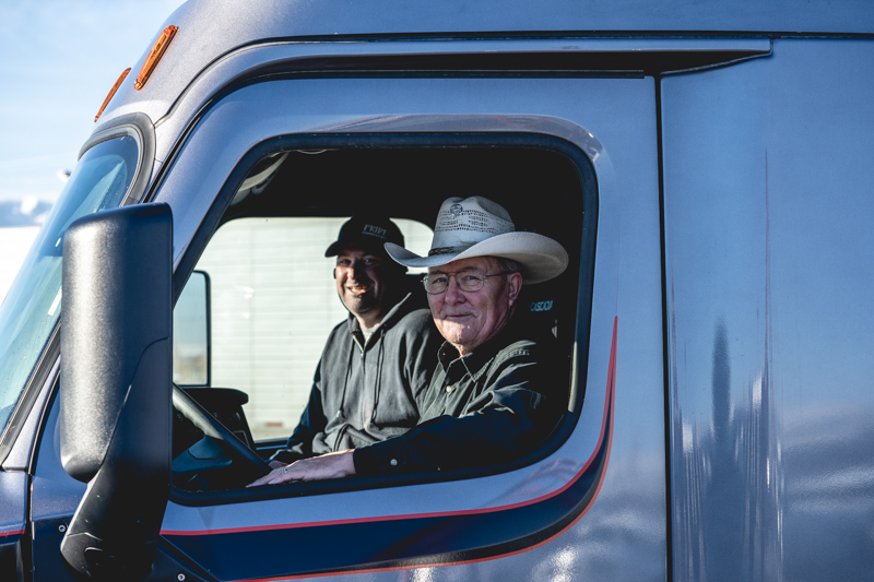 two pride transport employee in pride truck smiling